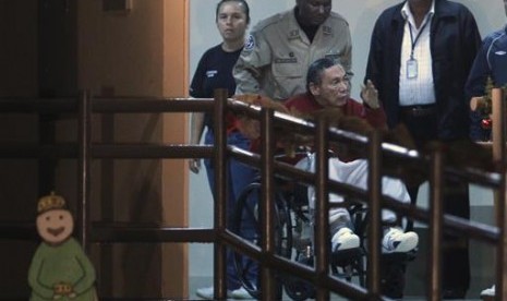 Mantan jenderal Panama Manuel Noriega didorong oleh polisi di atas kursi rodanya di penjara El Renacer di pinggiran Panama City, Panama pada 11 Desember 2011.