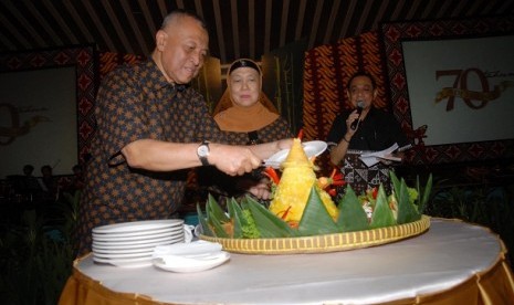 Mantan Menteri Koperasi dan UKM Adi Sasono memotong nasi tumpeng dengan didampingi istrinya Mala Maria Adi Sasono saat perayaan hari kelahirannya yang ke-70 serta peluncurkan buku 