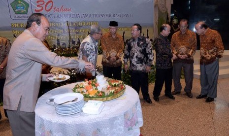 Mantan Menteri Transmigrasi dan Permukiman Perambah Hutan Siswono Yudo Husodo (kiri) memotong tumpeng pada peringatan 30 Tahun Persatuan Wredatama Transmigrasi (PWT) di Balai Makarti Mukti Tama, Jakarta, Selasa (17/5).