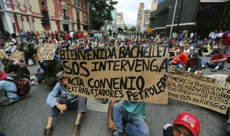 Mantan pekerja Petroleos de Venezuela (PDVSA) memprotes Presiden Venezuela Nicolas Maduro di depan kantor wakil presiden, Caracas, Kamis (20/6). Mereka sebelumnya dipecat dan menuntut pembayaran gaji.