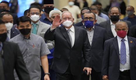 Mantan Perdana Menteri Malaysia Najib Razak, tengah, mengenakan masker, melambaikan tangan saat tiba di Pengadilan Banding di Putrajaya, Malaysia, Selasa, 23 Agustus 2022. Najib divonis 12 tahun penjara oleh pengadilan tinggi pada Juli 2020 , setelah dinyatakan bersalah atas penyalahgunaan kekuasaan, pelanggaran kriminal kepercayaan dan pencucian uang karena secara ilegal menerima 42 juta ringgit ($9,4 juta) dari SRC International, bekas unit 1MDB.