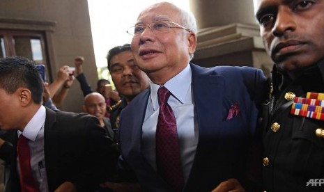 Mantan Perdana Menteri Malaysia, Najib Razak tiba di pengadilan untuk menjalani sidang perdananya, Rabu (4/7).