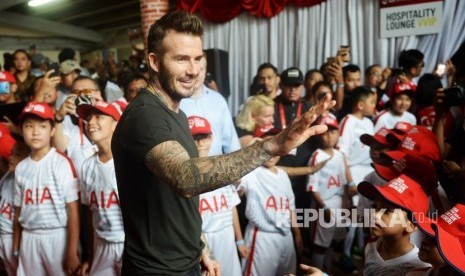 Mantan pesepak bola Manchester United dan Real Madrid David Beckham menyapa penggemarnya saat tiba di Stadion Soemantri Brojonegoro, Jakarta, Ahad (25/3). 