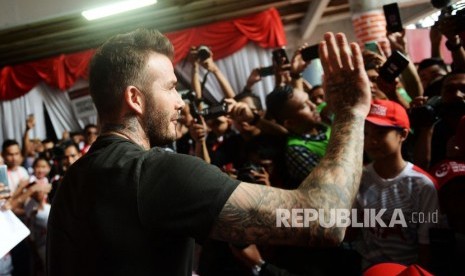 Mantan pesepak bola Manchester United dan Real Madrid David Beckham menyapa penggemarnya saat tiba di Stadion Soemantri Brojonegoro, Jakarta, Ahad (25/3). 