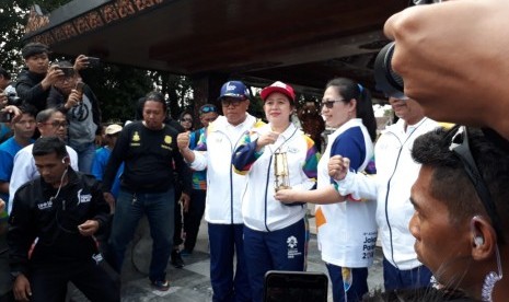 Mantan petenis meja nasional, Ling Ling Agustin menyerahkan obor atau torch relay Asian Games 2018 ke Menteri Koordinator bidang Pembangunan Manusia dan Kebudayaan (Menko PMK) Puan Maharani, di depan makam proklamator Indonesia Soekarno, di Kota Blitar, Jawa Timur, Jumat (20/7).