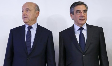 Mantan PM Prancis Francois Fillon (kanan) bersama lawannya Alain Juppe berpose usai keluarnya hasil Pilpres Prancis di putaran pertama, Senin (28/11).