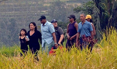 Mantan Presiden Amerika Serikat Barack Obama (keenam dari kiri) berjalan bersama keluarga saat berkunjung ke objek wisata Jatiluwih, Tabanan, Bali, Ahad (25/6). 