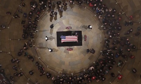 Mantan Presiden AS George W. Bush dan Ibu Negara Laura Bush meletakkan tangan mereka di atas peti bekas Mantan Presiden George HW Bush