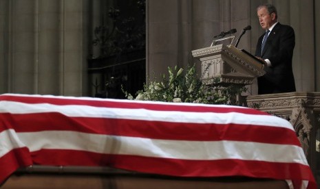  Mantan Presiden George W. Bush terdiam sesaat ketika berbicara di depan peti mati ayahnya, mantan Presiden George H.W. Bush, dalam prosesi Penguburan Kenegaraan di National Cathedral, di Washington, Rabu (5/12). 