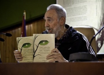 Mantan Presiden Kuba, Fidel Castro, saat menunjukkan dua eksemplar bukunya yang berjudul 