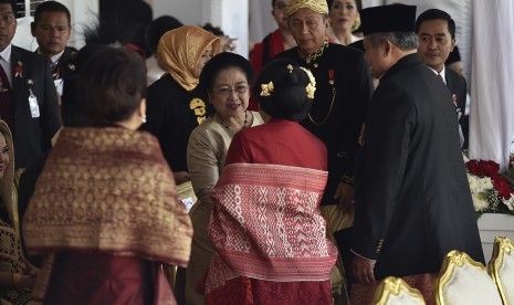 Mantan Presiden Megawati Soekarnoputri (tengah) berjabat tangan dengan mantan Presiden Susilo Bambang Yudhoyono (kanan) beserta istri Ani Yudhoyono (kedua kanan) saat menghadiri upacara peringatan detik-detik proklamasi kemerdekaan RI di Istana Merdeka, Jakarta, Kamis (17/8).