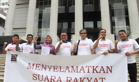 Mantan Wakil Menkum HAM, Denny Indrayana (tengah) bersama Penelitii utama NETGRIT, Hadar Nafis Gumay (ketiga kanan) dan Direktur PERLUDEM, Titi Anggraini (ketiga kiri) dan sejumlah aktivis Pemilu membentangkan spanduk usai mendaftarkan uji materi UU Nomor 7 Tahun 2017 tentang Pemilu, terutama yang terkait dengan syarat prosedur administratif di Gedung Mahkamah Konstitusi, Jakarta, Selasa (5/3/2019). 