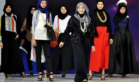 Indonesian Muslim designer poses with models in runaway. (illustration)