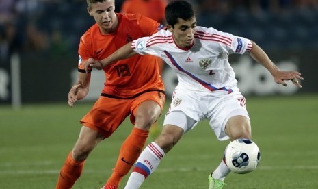 Marco van Ginkel of the Netherlands, left, and Russia's Ibragim Tsallagov fight for the possession during a UEFA European U21 Soccer Championship Group A match in Jerusalem, Sunday, June 9, 2013.