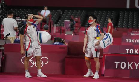 Marcus Fernaldi Gideon dari Indonesia (kiri) dan Kevin Sanjaya Sukamuljo bereaksi setelah dikalahkan oleh Aaron Chia dan Soh Wooi Yik dari Malaysia dalam pertandingan perempat final ganda putra di Olimpiade 2020, Kamis, 29 Juli 2021, di Tokyo, Jepang.