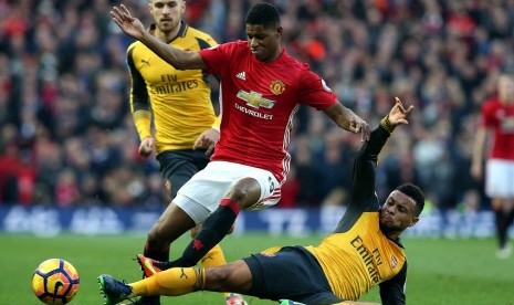 Marcus Rashford berebut bola dengan penggawa Arsenal, Francis Coquelin dalam bigmatch Liga Inggris antara Manchester United melawan Arsenal, Senin (19/11). Kedua tim bermain imbang 1-1.