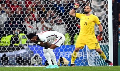 Marcus Rashford (kiri) dari Inggris bereaksi setelah gagal mengeksekusi penalti saat adu penalti di final Euro 2020 antara Italia dan Inggris di London, Inggris, Senin (12/7) dini hari WIB.