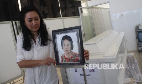 Maria Hamdani, memasang foto bibinya, Mayawati yang menjadi korban bom gereja Surabaya di Rumah Persemayaman Gotong Royong, Malang, Jawa Timur, Senin (14/5). 