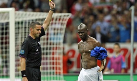  Mario Balotelli (kanan), striker timnas Italia, diganjar kartu kuning karena melakukan selebrasi lepas baju usai menjebol jala Jerman di semifinal Piala Eropa 2012. 