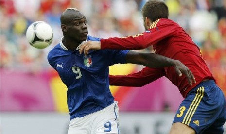  Mario Balotelli (kiri), striker timnas Italia, berebut bola dengan bek Spanyol, Gerard Pique, di laga perdana Grup C Piala Eropa 2012 di PGE Arena, Gdansk, Polandia, pada Ahad (10/6). 