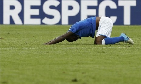 Mario Balotelli, striker timnas Italia, melampiaskan kekesalannya dengan memukul tanah usai diserang cacian rasis dalam pertandingan lawan Spanyol di laga perdana Grup C di Gdansk, Polandia, Ahad (10/6). 