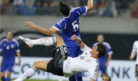 Mario Gomez (bawah), striker timnas Jerman, berebut bola dengan pemain Israel, Rami Gershon, dalam laga uji coba di Leipzig, Jerman, Kamis (31/5). 