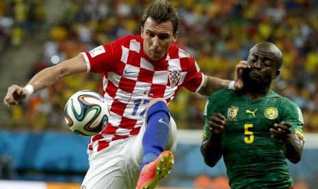 Mario Mandzukic (kiri) dari Kroasia vies denganDany Nounkeu Kamerun selama Piala Dunia FIFA 2014 grup A pertandingan babak penyisihan antara Kamerun dan Kroasia di Arena Amazonia di Manaus, Brasil, Rabu (18/6).   (EPA/Mast Irham).