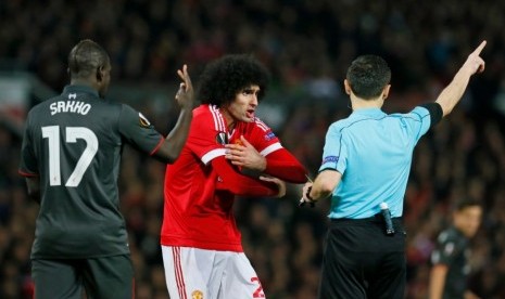 Marouane Fellaini (tengah) saat mendapatkan peringatan dari wasit.