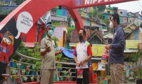 Marselino Najoan - Regional Sales Manager Jawa Tengah Nippon Paint Indonesia (tengah) meninjau hasil kreativitas mural di jembatan Kampung Pelangi didampingi oleh HS Handoyo - Hotel Manager Corporate PT Kekancan Mukti (kanan) dan Ndan Slawi - Ketua Pokdarwis (Kelompok Sadar Wisata) Kampung Pelangi (kiri) di kawasan Kampung Pelangi Semarang, Jawa Tengah