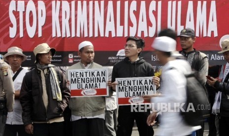  Masa Hizbut Tahrir Indonesia (HTI) melakukan aksi Menolak Kriminalisasi dan Pelecehan Terhadap Ulama saat berlangsungnya Hari Bebas Kendaraan Bermotor (HBKB) di kawasan silang Monas, Jakarta, Ahad (5/2). 