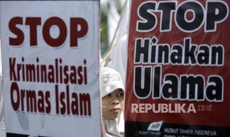 Masa Hizbut Tahrir Indonesia (HTI) melakukan aksi Menolak Kriminalisasi dan Pelecehan Terhadap Ulama saat berlangsungnya Hari Bebas Kendaraan Bermotor (HBKB) di kawasan silang Monas, Jakarta, Ahad (5/2). 