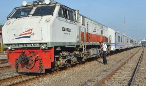 Masinis melakukan pengecekan rangkaian Kereta Api (KA) kelas eksekutif sesaat sebelum berangkat.