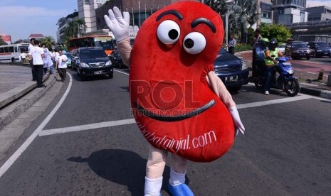   Maskot Ginjal berjalan saat melakukan kampanye pada hari ginjal sedunia di Bundaran HI, Jakarta, Kamis (14/3).   (Republika/ Tahta Aidilla)