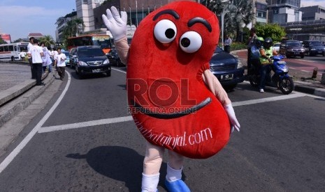 Maskot Ginjal berjalan saat melakukan kampanye pada hari ginjal sedunia di Bundaran HI, Jakarta