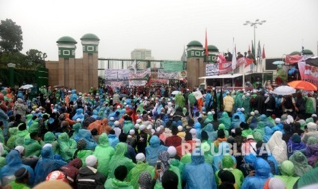  Massa Aksi 212 memadati pintu gerbang DPR RI dalam guyuran hujan, Jakarta, Selasa (21/2). 