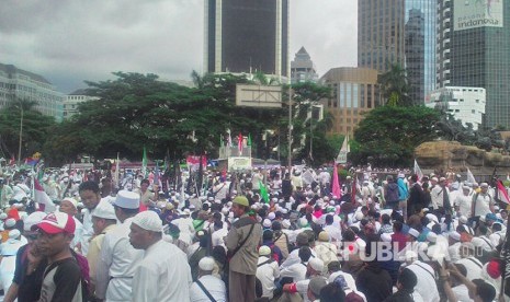 Massa aksi 313 dengan tertib duduk untuk berdzikir di kawasan Patung Kuda, Jumat (31/3).