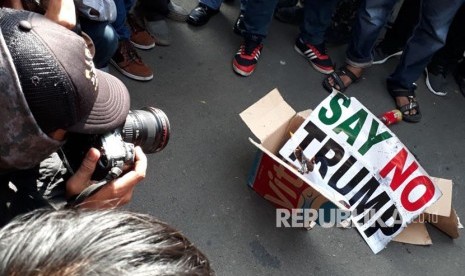 Massa aksi damai darurat Yerusalem membakar kardus dengan kertas bertuliskan Say No To Trump sebagai ganti ban yang sebelumnya dipadamkan oleh kepolisian di depan gedung Kedutaan Besar Amerika Serikat, Jumat (8/12). 