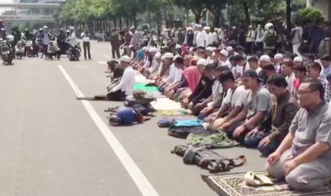 Massa aksi damai melakukan shalat berjamaah di Jalan MH Thamrin, Jakarta Pusat, Rabu (22/5).