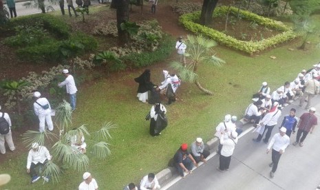 Massa Aksi Damai membersihkan sampah yang tertinggal di taman di sisi jalan Medan Merdeka Barat, Jumat (4/11).