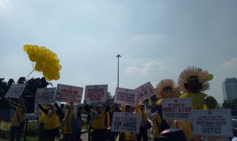 Massa aksi yang tergabung dalam alumni keluarga besar Universitas Indonesia (UI) di patung kuda, Jalan Medan Merdeka Barat, Jakarta Pusat, Selasa (18/6). 