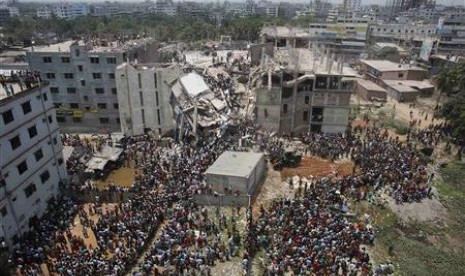 Massa berkumpul di lokasi runtuhnya gedung di luar Dhaka, Bangladesh, Kamis (25/4). Insiden ini kemudian memicu protes para buruh.