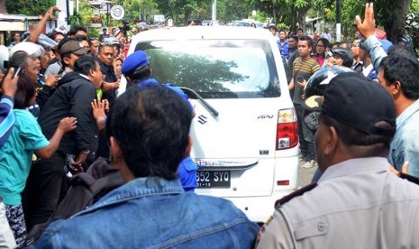 Massa berusaha menyerang mobil yang membawa tersangka Agustinus usai menjalani proses pra-rekonstruksi pembunuhan Angeline di Jalan Sedap Malam, Kota Denpasar, Bali, Kamis (11/6). 