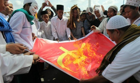 Massa dari Front Pembela Islam (FPI) dan Front Pancasila membakar kain bersimbol komunis di depan kantor Gubernur Jawa Timur, Surabaya, Jawa Timur.