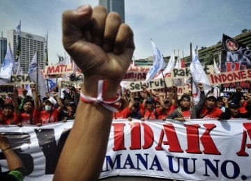 Massa dari gabungan organisasi buruh dan pekerja melakukan aksi memperingati Hari Buruh Internasional (May Day), di Bundaran Hotel Indonesia, Jakarta, Minggu (1/5). Aksi May Day kali ini mengangkat isu 