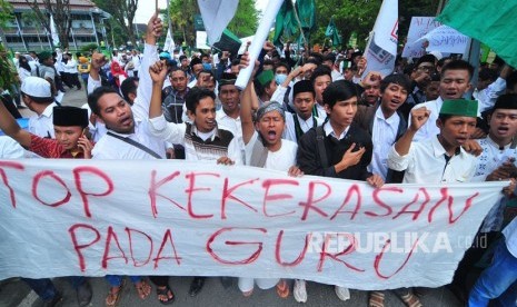 Massa dari PGRI, KAHMI, HMI dan siswa se Madura melakukan salat gaib untuk mendiang Ahmad Budi Cahyanto guru SMAN 1 Torjun yang tewas dianiaya siswanya saat aksi solidaritas Duka Budi Duka Kita di depan Polres Sampang, Jawa Timur, Sabtu (3/2). 