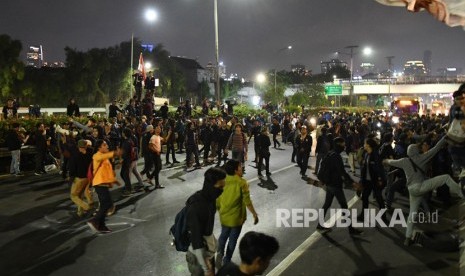 Massa mahasiswa memblokade Tol Dalam Kota saat berunjuk rasa menolak UU KPK dan pengesahan RUU KUHP di depan kompleks Parlemen di Jakarta, Senin (23/9/2019) malam.