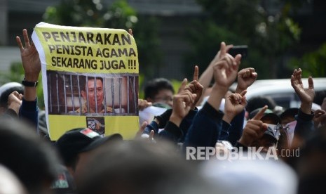 Massa melakukan aksi saat sidang perdana terdakwa penistaan agama, Basuki Tjahaja Purnama di Pengadilan Negeri Jakarta Utara, Selasa, (13/12).