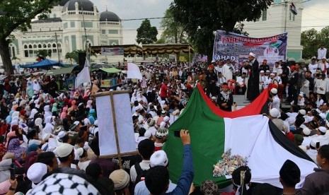 Massa memadati kawasan Masjid Raya Al Mashun saat digelar Tabligh Akbar Peduli Palestina, di Medan, Sumatra Utara, Ahad (17/12). Mereka menyerukan pembelaan untuk Palestina dan mengecam pengakuan sepihak Presiden Amerika Serikat Donald Trump atas Yerusalem sebagai ibu kota Israel.