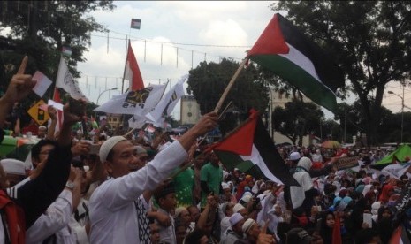 Massa memadati kawasan Masjid Raya Al Mashun saat digelar Tabligh Akbar Peduli Palestina, di Medan, Sumatra Utara, Ahad (17/12). Mereka menyerukan pembelaan untuk Palestina dan mengecam pengakuan sepihak Presiden Amerika Serikat Donald Trump atas Yerusalem sebagai ibu kota Israel.