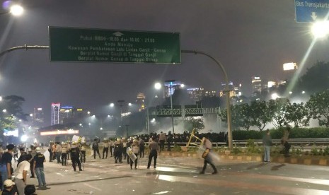 Massa pelajar bentrok dengan aparat kepolisian saat dipukul mundur di Jalan Gatot Subroto, Jakarta Selatan ke arah Putaran Semanggi, Rabu malam (25/9). 